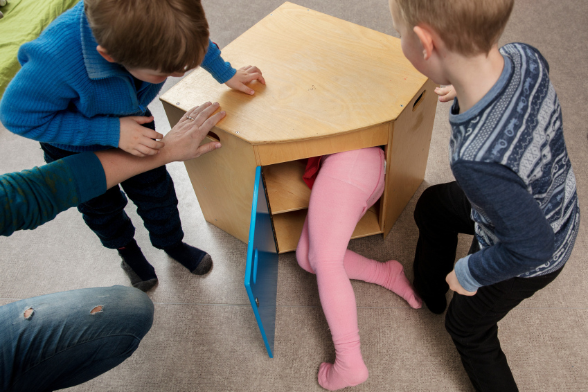 Et barn klatrer inn i et skap.