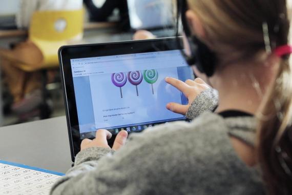 Jente som jobber med matematikkoppgaver på skjerm